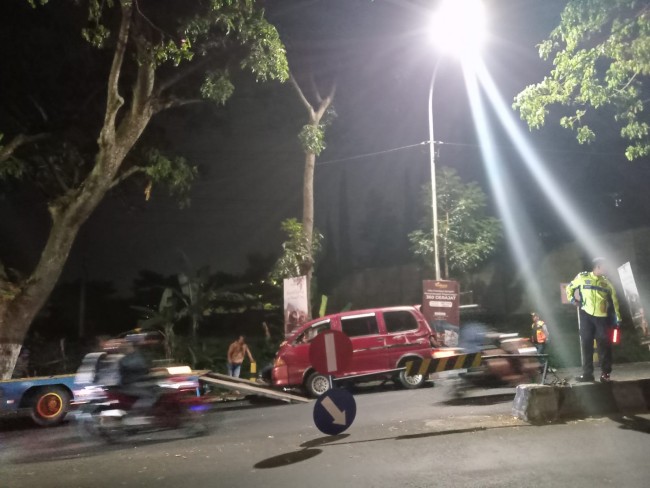 Minibus menghantam pembatas jalan dan rambu lalin.